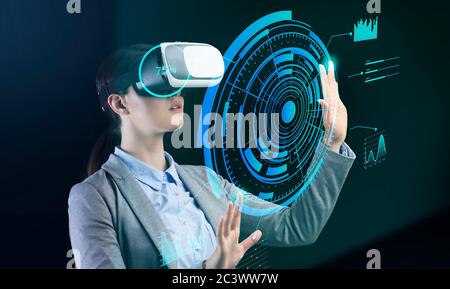 Technologies et entreprises. Femme d'affaires en lunettes VR en appuyant sur le bouton à l'écran virtuel Banque D'Images