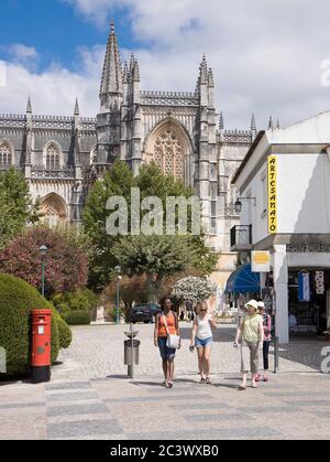 Touristes marchant dans la rue à Batalha Portugal avec des boutiques de monastère et boîte aux lettres rouge Banque D'Images