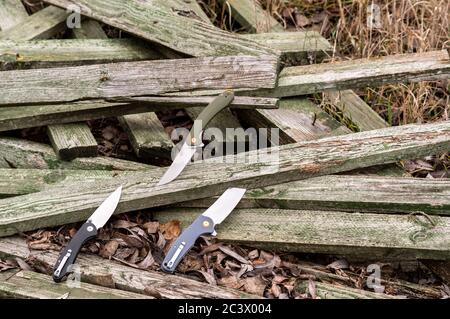 Trois couteaux sont sur des planches en bois. Photo de couteaux sur la nature. Extérieur. Banque D'Images