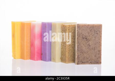 Concept de barres de savon écologiques faites à la main. Photo d'une rangée de barres de savon colorées faites maison isolées sur fond blanc Banque D'Images