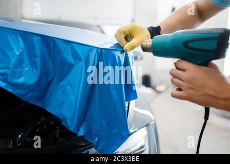 L'emballage de voiture, homme avec sèche-linge installe le film de gros plan Banque D'Images
