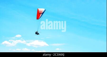 Parachute coloré avec parachutisme sur fond bleu ensoleillé. Un style de vie actif. Sport extrême. Concept de vacances, vacances, tourisme. Horizontal. Vue aérienne de Rio de Janeiro avec eau turquoise Banque D'Images