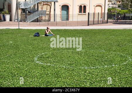 Milan, Italie 06.20.2020: Cercles sociaux de distanciation peints sur l'herbe dans le nouveau parc de la Bibliothèque des arbres à Milan Banque D'Images