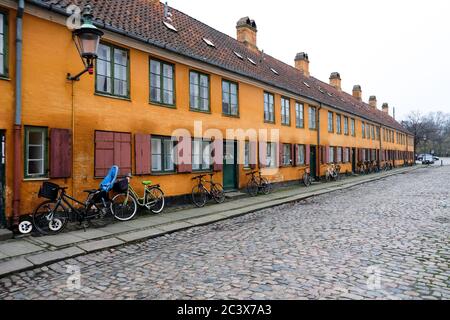 Vide rue déserte dans une capitale populaire européenne Copenhague, Danemark. Beaux bâtiments peints en orange vif. Hygge maisons sans personnes. Banque D'Images