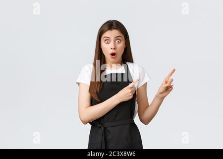 Concept de petite entreprise, employés et café. Une femme Barista brunette choquée et excitée se présentant à Banner. Magasin d'alimentation impressionné Banque D'Images