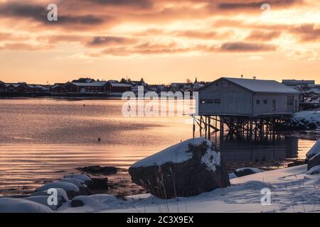 Gîte avec village de pêcheurs sur la côte au coucher du soleil dans les îles Lofoten, Norvège Banque D'Images