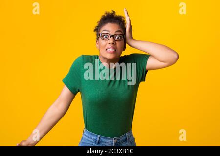 Surprise afro femme claquant sa tête au studio Banque D'Images