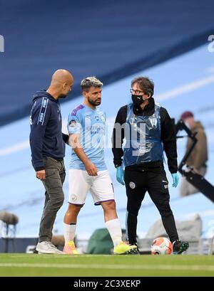 Sergio Aguero de Manchester City s'entretient avec le directeur de PEP Guardiola alors qu'il se promène sur le terrain blessé lors du match de la Premier League au Etihad Stadium de Manchester. Banque D'Images