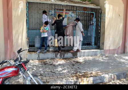 Les citoyens remplissent leurs bidons d'eau du robinet public alors qu'ils sont confrontés à une pénurie d'eau potable dans leur région, à Quetta, le lundi 22 juin 2020. Banque D'Images