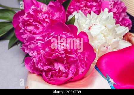 Gros plan sur fuchsia et pivoines blanches, foulard en soie sur fond lilas. Idée pour poster, carte postale, papier peint Banque D'Images