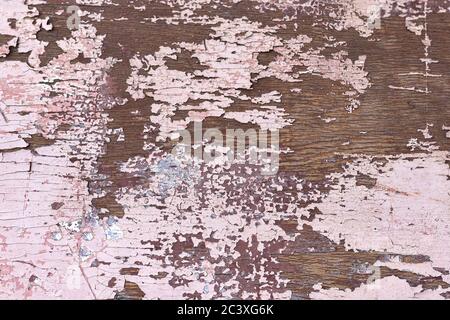 Texture de la peinture écaillée rose sur une surface en bois brun. Arrière-plan, fond d'écran, gros plan, vue du dessus Banque D'Images