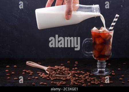 Dans un verre de café froid, on a versé du lait dans une bouteille Banque D'Images