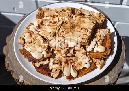 Vue rapprochée et vue de dessus des morceaux oblongs de gâteau maison à la crumble avec confiture de fraise recouverte de meringue servi sur une table en bois. Gâteau Streuselkuchen Banque D'Images