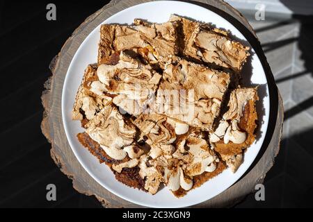 Morceaux de gâteau maison à la crumble avec confiture de fraise couverts de meringue sur une assiette blanche servie sur une table en bois. Gâteau Streuselkuchen, vue du dessus Banque D'Images