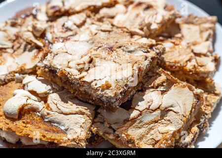 Morceaux de gâteau à la crumble maison avec confiture de fraise enrober de meringue servi sur une assiette blanche. Streuselkuchen Cake, gros plan Banque D'Images