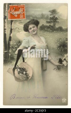 Carte postale française sentimentale du début des années 1900, jeune femme avec capot de fleurs tenant un bouquet de roses, vers 1912, France Banque D'Images