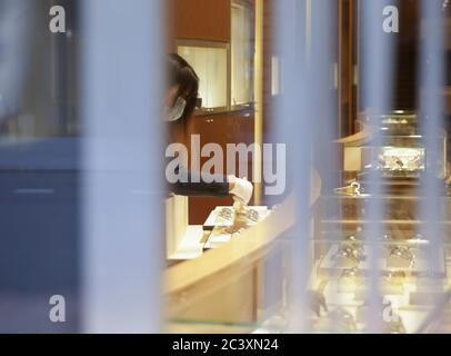 New York, États-Unis. 22 juin 2020. Une vendeuse de la boutique de montres de luxe Omega de Fifth Avenue dépoussière les vitrines avant d'ouvrir pour affaires quand New York City entre dans la phase 2 d'un plan de réouverture en quatre parties après avoir été fermé pendant trois mois en raison de COVID-19 le lundi 22 juin 2020. La phase 2 ramène officiellement les restaurants, les bars, la vente au détail en magasin, entre autres choses. Photo de John Angelillo/UPI crédit: UPI/Alay Live News Banque D'Images