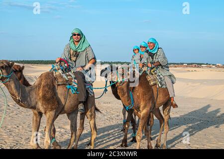 Un groupe de touristes avec des turbans à cheval dans le désert du Sahara, Tunisie Banque D'Images