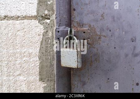 Le cadenas sur la porte métallique se ferme. Photo de haute qualité Banque D'Images