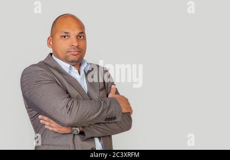 Un jeune homme afro-américain attrayant a croisé les bras sur sa poitrine. Homme noir méditant, méditant une idée, une décision ou un concept Banque D'Images