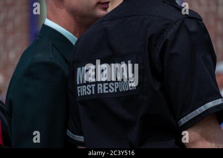 Un médecin portant l'uniforme d'un premier répondant médical. Le maillot est bleu marine avec des lettres et des rayures grises réfléchissantes. Banque D'Images