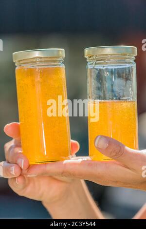 Femme tenant des pots de miel qui ont été fraîchement extraits, tendu et mis en bouteille Banque D'Images