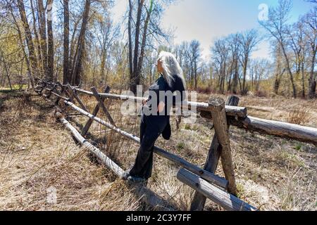 États-Unis, Idaho, Bellevue, femme sénior se détendant sur une barrière de chemin de fer rustique Banque D'Images