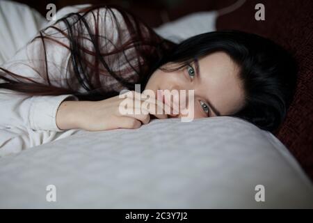 Portrait of young woman lying on bed Banque D'Images