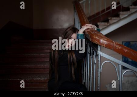 Portrait of young woman sitting on stairs Banque D'Images
