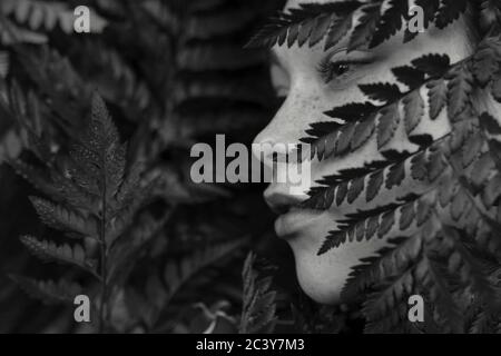 Visage de la jeune femme recouvert de plantes Banque D'Images