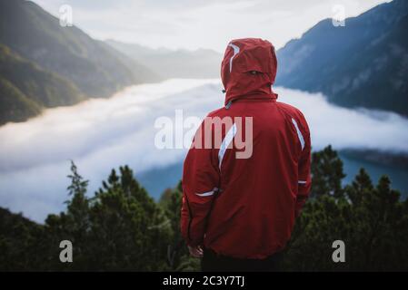 Autriche, Plansee, vue arrière de l'homme en blouson rouge debout dans les Alpes autrichiennes Banque D'Images