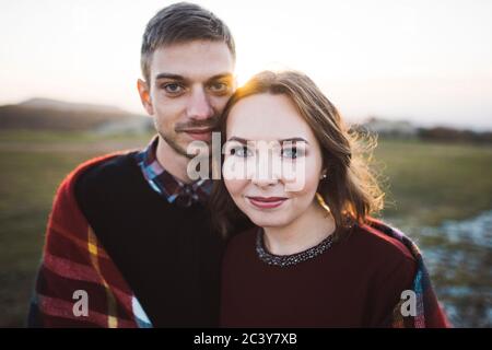Ukraine, Crimée, Jeune couple couvert de plaid au coucher du soleil Banque D'Images