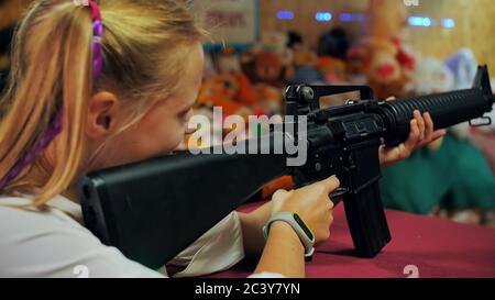 Une jeune fille qui a un fusil tire à une portée de tir. Banque D'Images