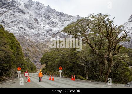 Milford Sound, Nouvelle-Zélande, juin 20 2020 : la route traversant le tunnel Homer devient un moyen pour les touristes qui voyagent à l'intérieur et à l'extérieur. Une travailleuse de la route. Banque D'Images