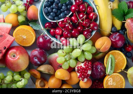 Fruits frais et sains sur fond gris. Aliments riches en antioxydants, glucides, minéraux et vitamines. Aliments pour stimuler l'immunité. Vue de dessus Banque D'Images