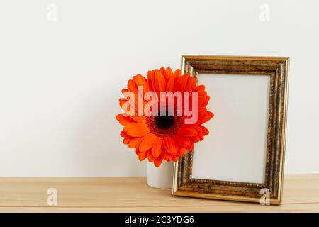 Cadre photo avec fleur de gerbera orange sur table en bois Banque D'Images
