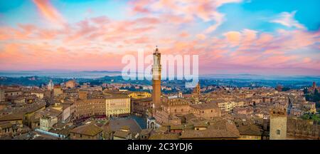 Paysage urbain de Sienne au coucher du soleil, avec Piazza del Campo et Torre del Mangia. La photo est prise de la tour de la cathédrale de Sienne. Banque D'Images