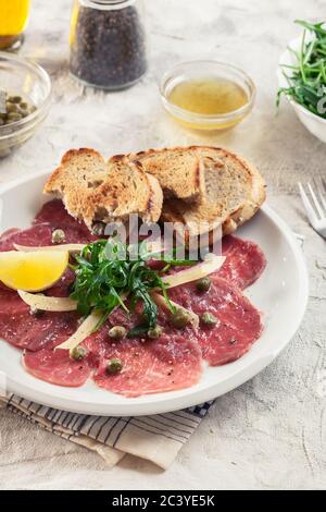 Carpaccio de bœuf avec arugula et parmesan. Cuisine italienne Banque D'Images