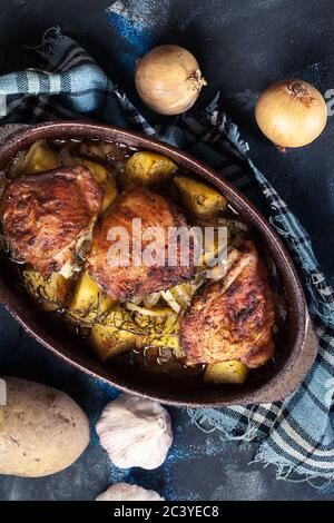 Cuisses de poulet rôties et pommes de terre dans un plat de cocotte Banque D'Images