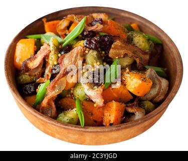 Courge musquée rôtie avec pousses de bruxelles et bacon dans une assiette en céramique. Isolé sur fond blanc. Banque D'Images