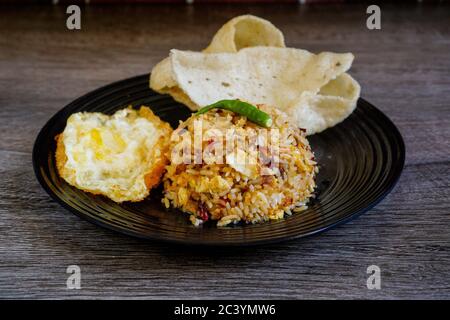 Riz frit épicé avec piment sec et œuf frit et craquelins de poisson. Banque D'Images