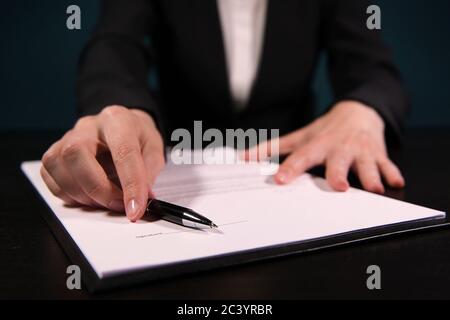 femme dans un procès d'affaires propose de signer un accord, en favorisant le contrat imprimé Banque D'Images