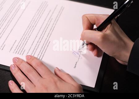 femme appose une signature sur le contrat, gros plan Banque D'Images