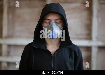 Un adolescent dans un respirateur regarde vers le bas Banque D'Images