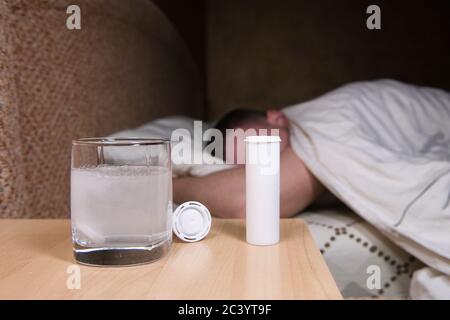 le comprimé se dissout dans l'eau, et à l'arrière-plan, un homme se lance et tourne Banque D'Images