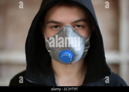 Un adolescent dans un respirateur en état de marche regarde directement le appareil photo Banque D'Images