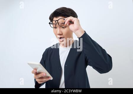 Jeune homme regardant agité à l'affichage de lui smartphone, impressionné par le contenu multimédia du Web Banque D'Images