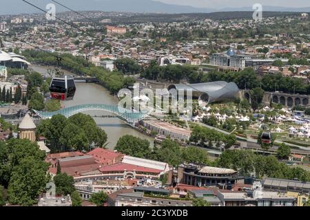 Vue de la forteresse de Narikala: Téléphériques, pont de la paix, Tbilissi, Géorgie, construction en acier et verre éclairée par de nombreuses LED, au-dessus de la Kura Banque D'Images