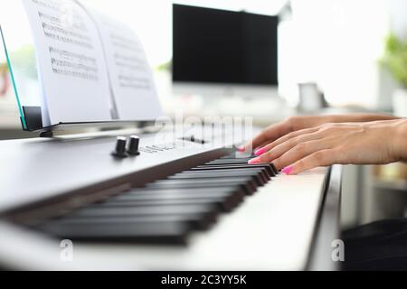 Les mains de la jeune femme jouent du piano à la maison Banque D'Images