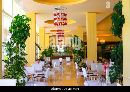 L'intérieur européen jaune de la cafétéria, bar, salle à manger publique, café, aire de restauration, buffet, restaurant avec des chaises blanches élégantes. Magnifique Banque D'Images